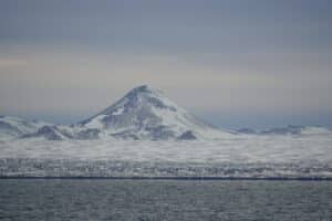 iceland explorer day trips photo - shows perfect cone shaped mountain on the reykjanes peninsular in iceland, all covered in snow