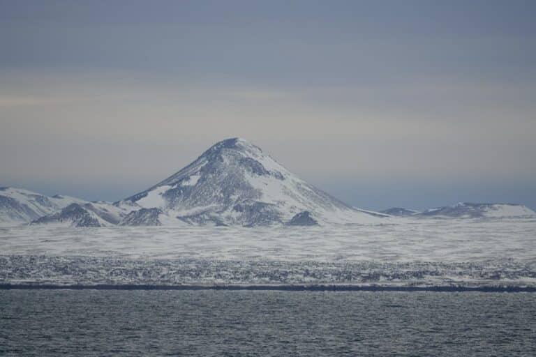 iceland explorer day trips photo - shows perfect cone shaped mountain on the reykjanes peninsular in iceland, all covered in snow