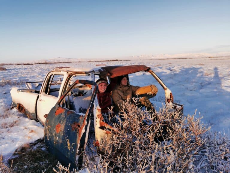 quality airport transfer in winter - not in this car. The photo is of two people in an obviously abandoned car that is rusted with plants growing out of it! 