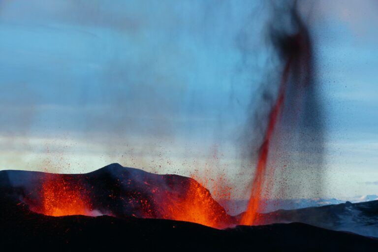 Volcanoes exploding. Lave being spewed up in a line from a crack. see the volcano