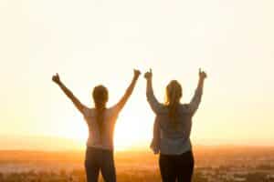 konudager - womans day in Iceland is a day celebrating women. So this image is two women cheering with their arms up, facing into the sun.