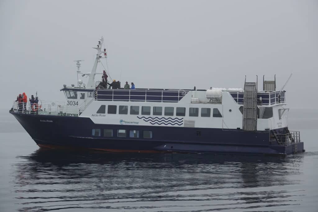 Classic white and blue boat whale watching from Reykjavík in fog